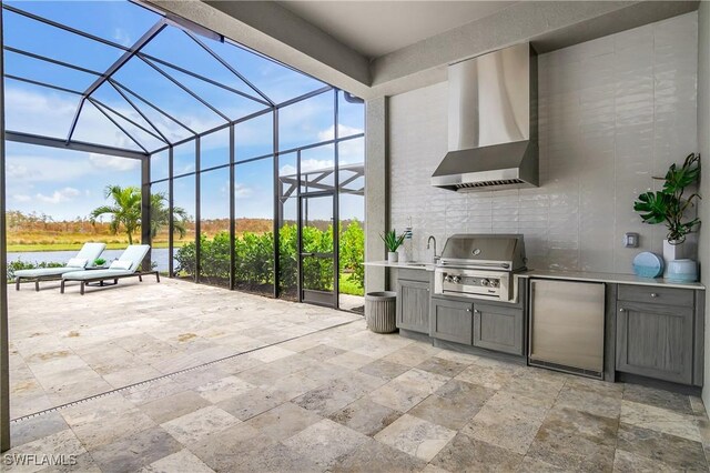 view of patio / terrace featuring an outdoor kitchen, sink, a water view, glass enclosure, and grilling area