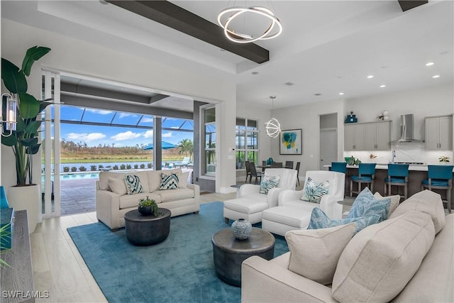 living room featuring a chandelier, a water view, and light hardwood / wood-style flooring