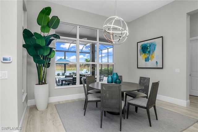 dining area featuring light hardwood / wood-style floors and an inviting chandelier