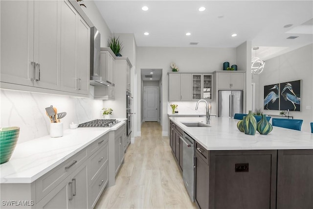 kitchen with a spacious island, sink, hanging light fixtures, and appliances with stainless steel finishes