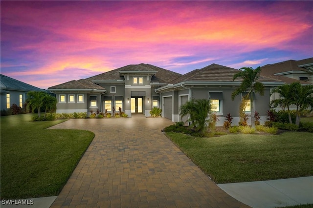 prairie-style home with french doors, a yard, and a garage