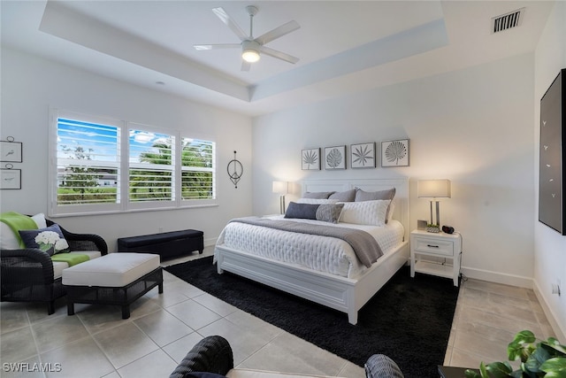 bedroom with light tile patterned floors, a raised ceiling, and ceiling fan