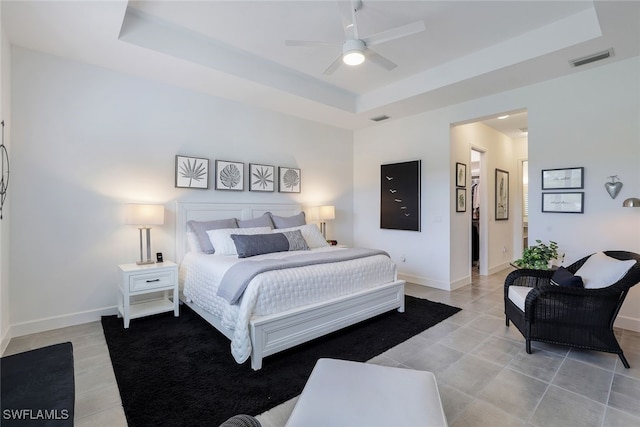 bedroom with a raised ceiling and ceiling fan