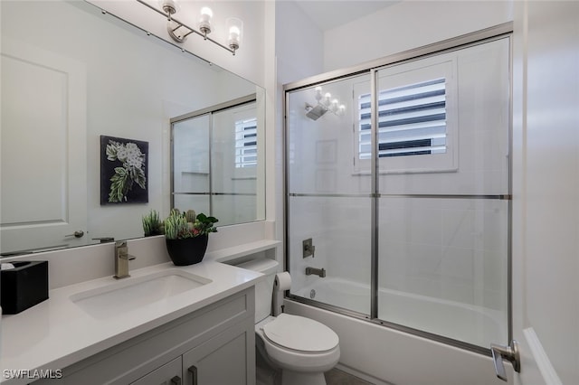 full bathroom featuring vanity, enclosed tub / shower combo, a healthy amount of sunlight, and toilet