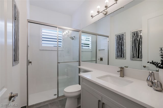 bathroom featuring toilet, hardwood / wood-style floors, walk in shower, and vanity