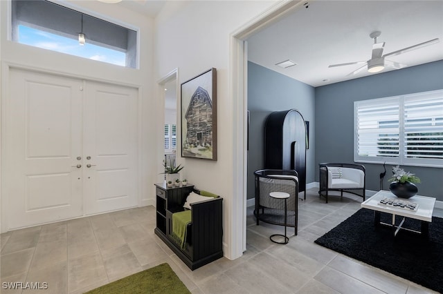 foyer featuring ceiling fan and light tile patterned floors