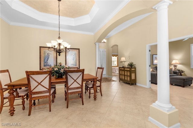 tiled dining area with an inviting chandelier, a tray ceiling, crown molding, and ornate columns