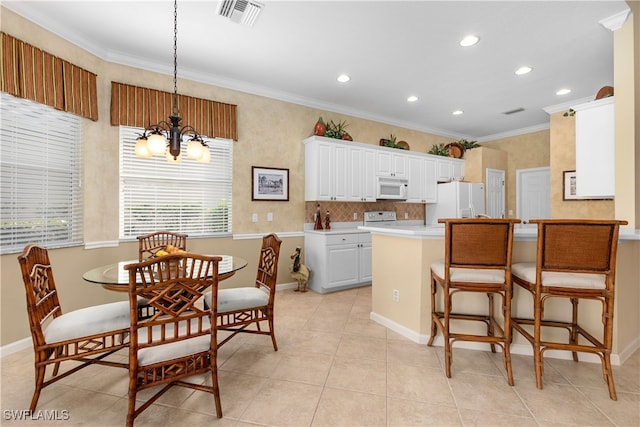 kitchen with white cabinets, white appliances, pendant lighting, crown molding, and a chandelier