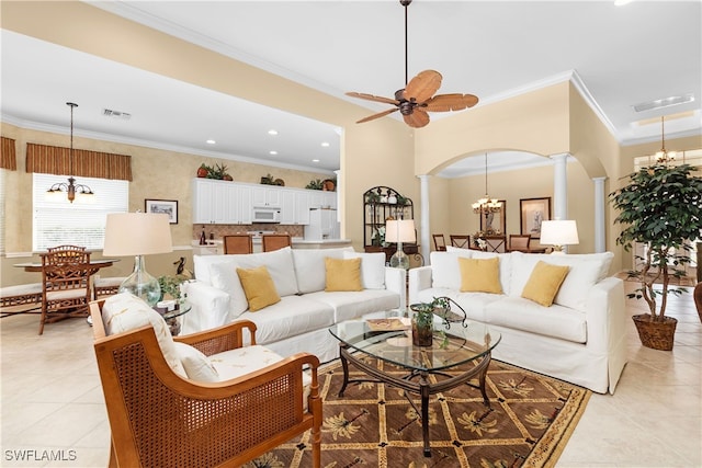 tiled living room with ceiling fan with notable chandelier, crown molding, and decorative columns