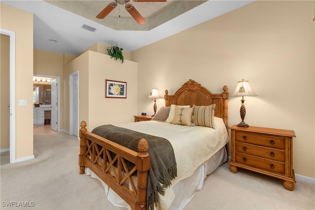 bedroom with light carpet, ensuite bathroom, and ceiling fan