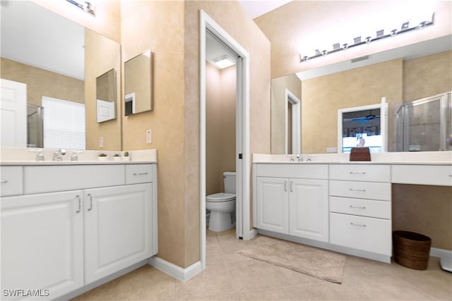 bathroom with vanity, toilet, and a shower with shower door