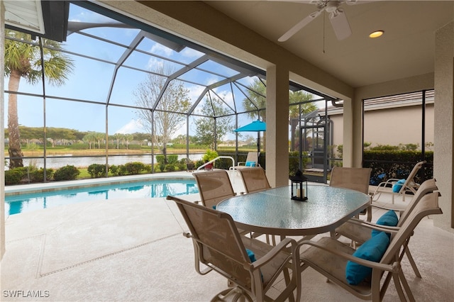 view of patio / terrace featuring ceiling fan, a water view, and a lanai