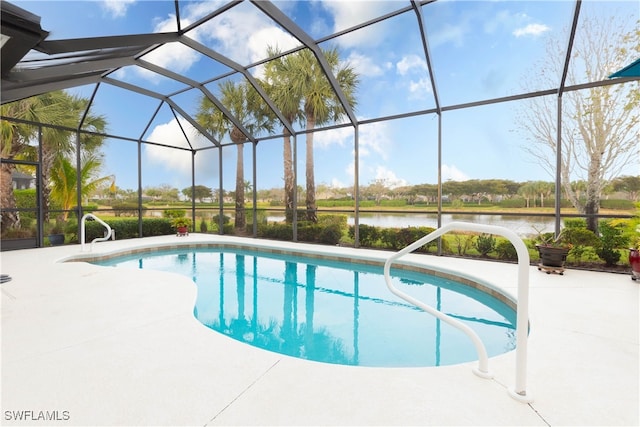 view of swimming pool featuring glass enclosure, a water view, and a patio area