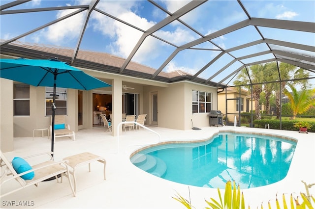 view of pool with ceiling fan, a patio, a grill, and a lanai