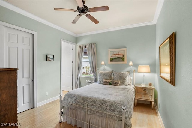 bedroom featuring a ceiling fan, light wood-style floors, baseboards, and ornamental molding