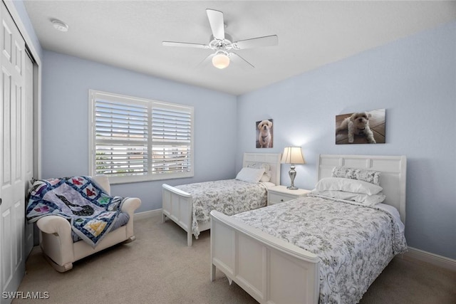 bedroom featuring a closet, light carpet, ceiling fan, and baseboards