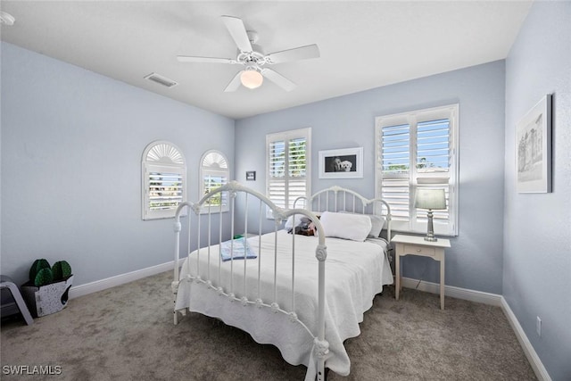 carpeted bedroom featuring visible vents, baseboards, and ceiling fan