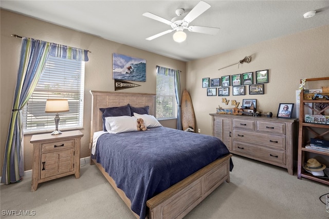 bedroom with ceiling fan and light carpet