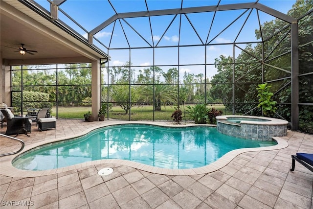 view of pool featuring a patio, a pool with connected hot tub, glass enclosure, and a ceiling fan