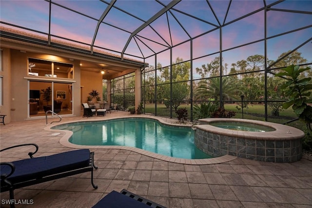 pool at dusk with a pool with connected hot tub, a patio, and glass enclosure