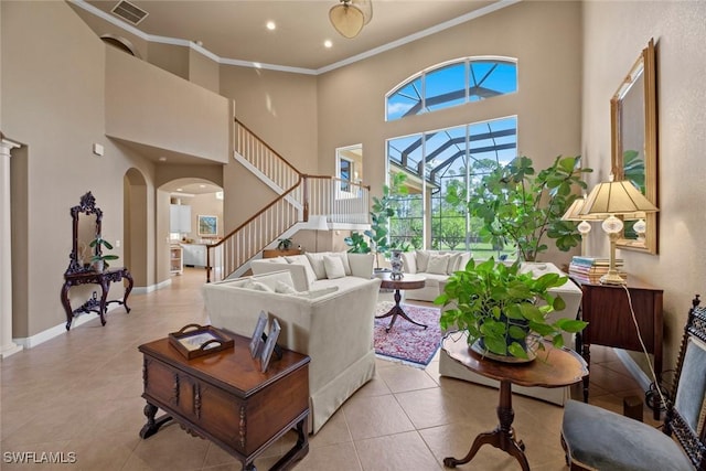living room featuring visible vents, arched walkways, a high ceiling, crown molding, and stairs