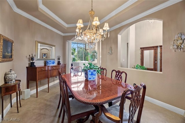 dining area with a notable chandelier, baseboards, ornamental molding, a raised ceiling, and arched walkways