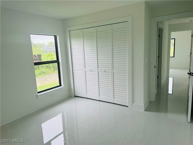 unfurnished bedroom with a closet and light tile patterned floors