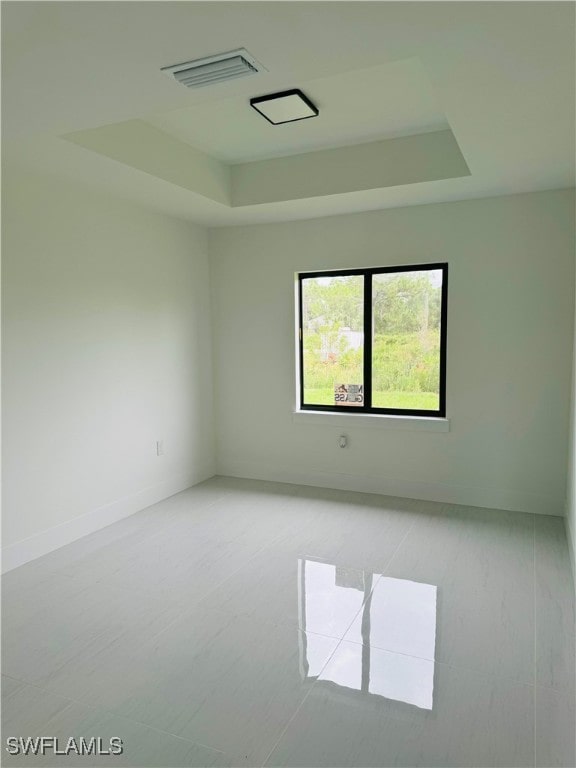 empty room featuring a tray ceiling