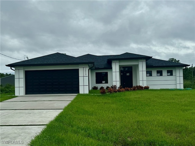 view of front of property featuring a front yard and a garage