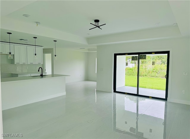 empty room with a raised ceiling and sink