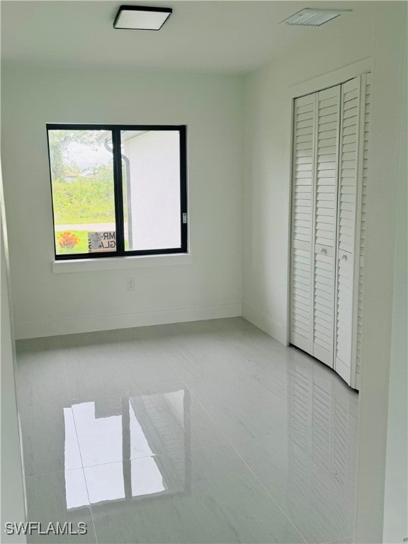 unfurnished bedroom with a closet and light tile patterned floors