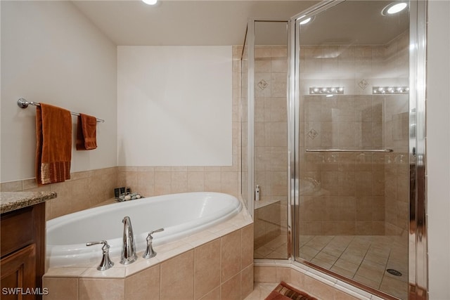 bathroom with vanity and shower with separate bathtub