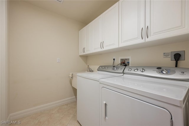 laundry room with light tile patterned floors, cabinets, sink, and washer and dryer