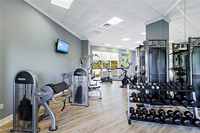 gym with light hardwood / wood-style floors and crown molding