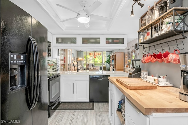 kitchen featuring black appliances, sink, a raised ceiling, white cabinetry, and wooden counters