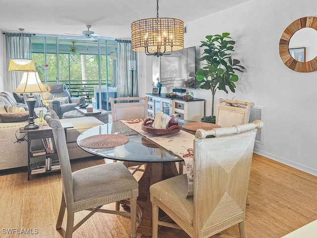 dining space with light hardwood / wood-style floors and ceiling fan with notable chandelier