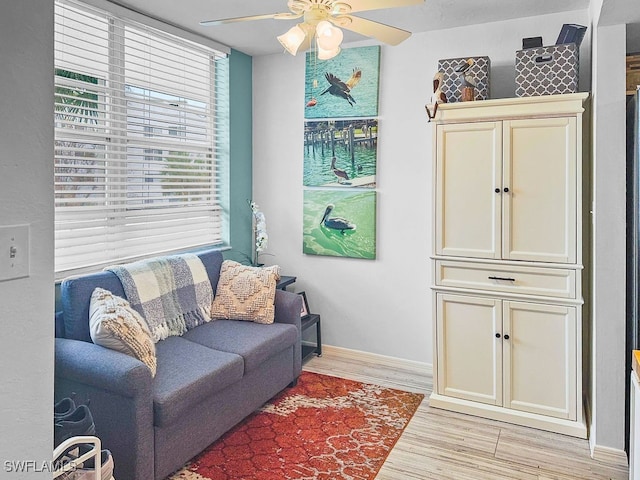 living room featuring light hardwood / wood-style flooring and ceiling fan