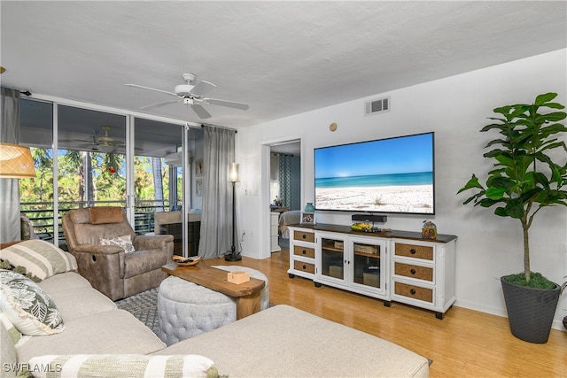 living room featuring wood-type flooring and ceiling fan