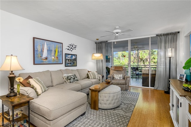 living room with light hardwood / wood-style flooring and ceiling fan