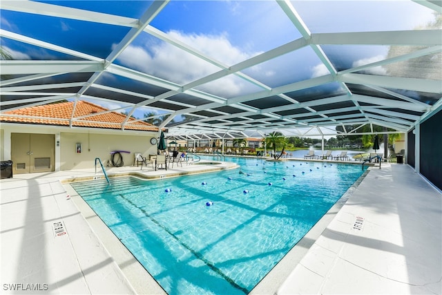 view of pool with a patio and glass enclosure