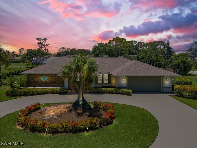 view of front of property featuring a garage and a yard