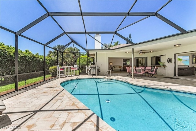 view of pool featuring ceiling fan, a patio area, and glass enclosure