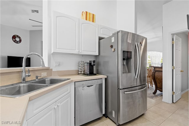 kitchen featuring light tile patterned flooring, appliances with stainless steel finishes, sink, and white cabinetry