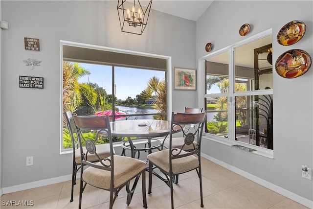 tiled dining space featuring a chandelier, a water view, and a wealth of natural light