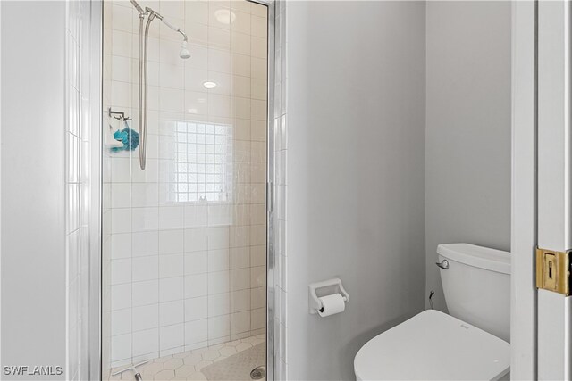 bathroom with toilet and a shower with shower door