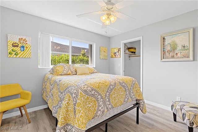 bedroom with ceiling fan, hardwood / wood-style flooring, a closet, and a spacious closet