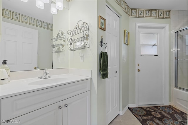 bathroom featuring tile patterned flooring, vanity, and enclosed tub / shower combo