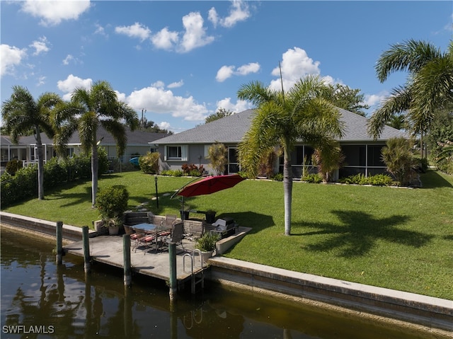 rear view of house featuring a water view and a yard