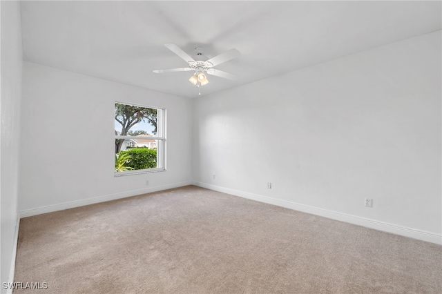 empty room featuring ceiling fan and light carpet