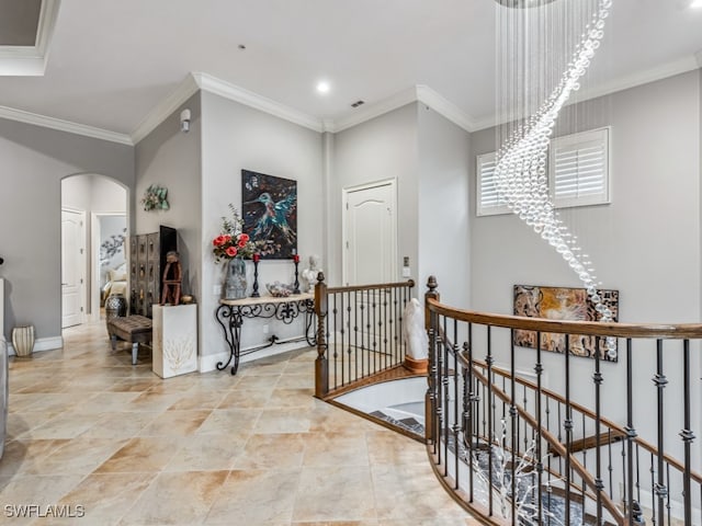 hall featuring crown molding and a chandelier